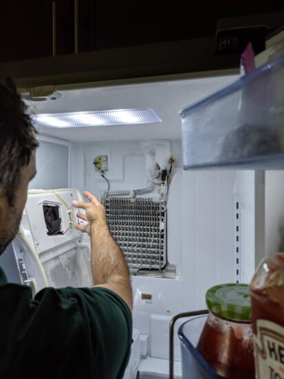 Terchnician opens the evaporator cover on Samsung fridge