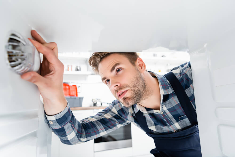 man repairing an lg refrigerator