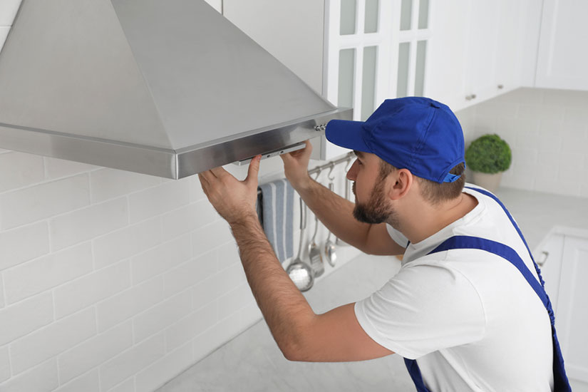 appliance repair technician working on rangehood