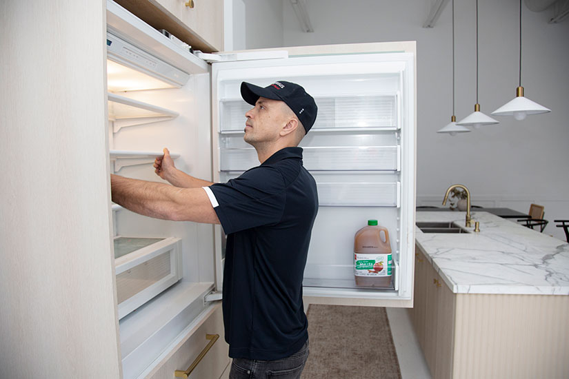 Technician repairing a French door refrigerator