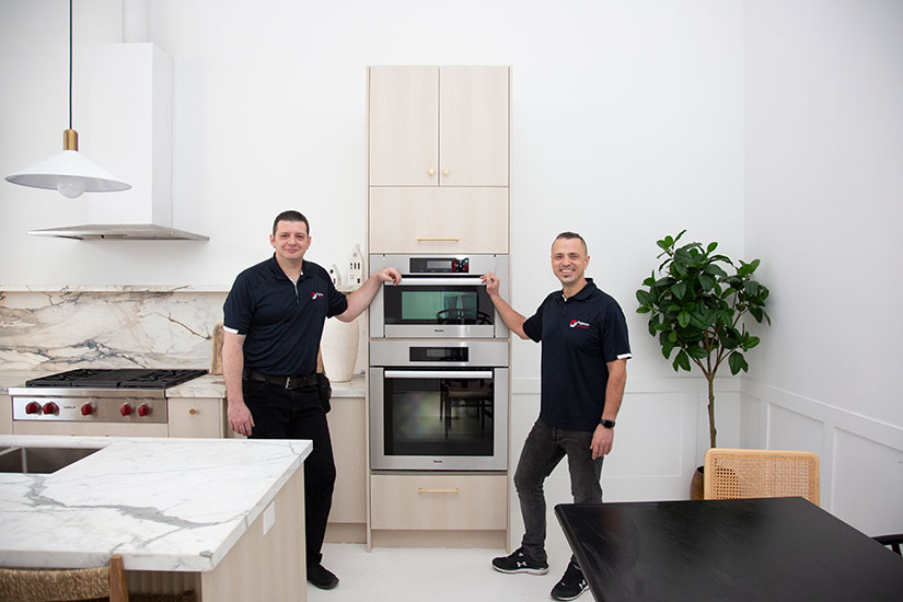 Two appliance repair technicians from Pegasus installing microwave/wall oven combo
