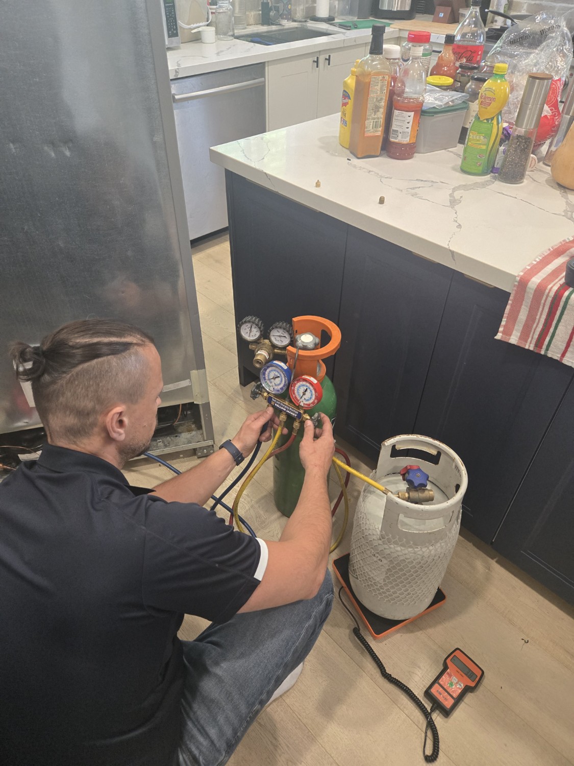Technician diagnosing sealed system on Frigidaire built-in refrigerator