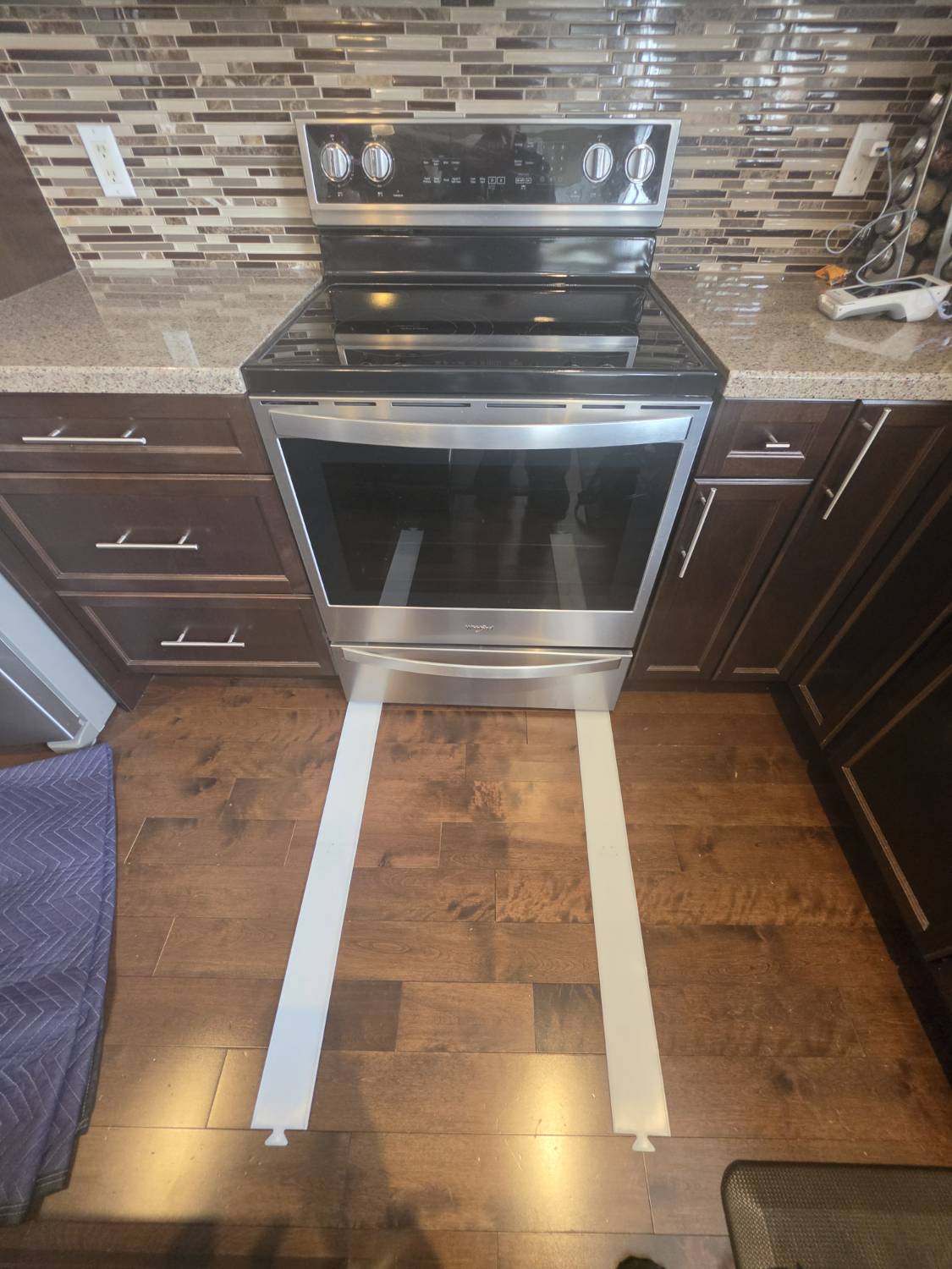 Electric range safely pulled out for repair using floor protection in London Ontario